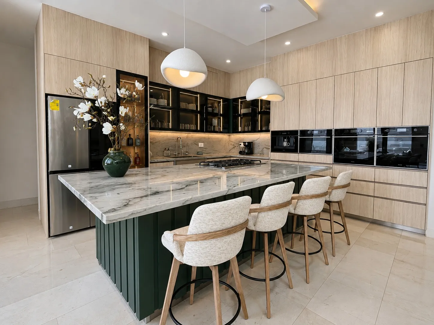 Cocina entregada por Kastell con isla de mármol verde, bancos y alacenas de vidrio con marco negro