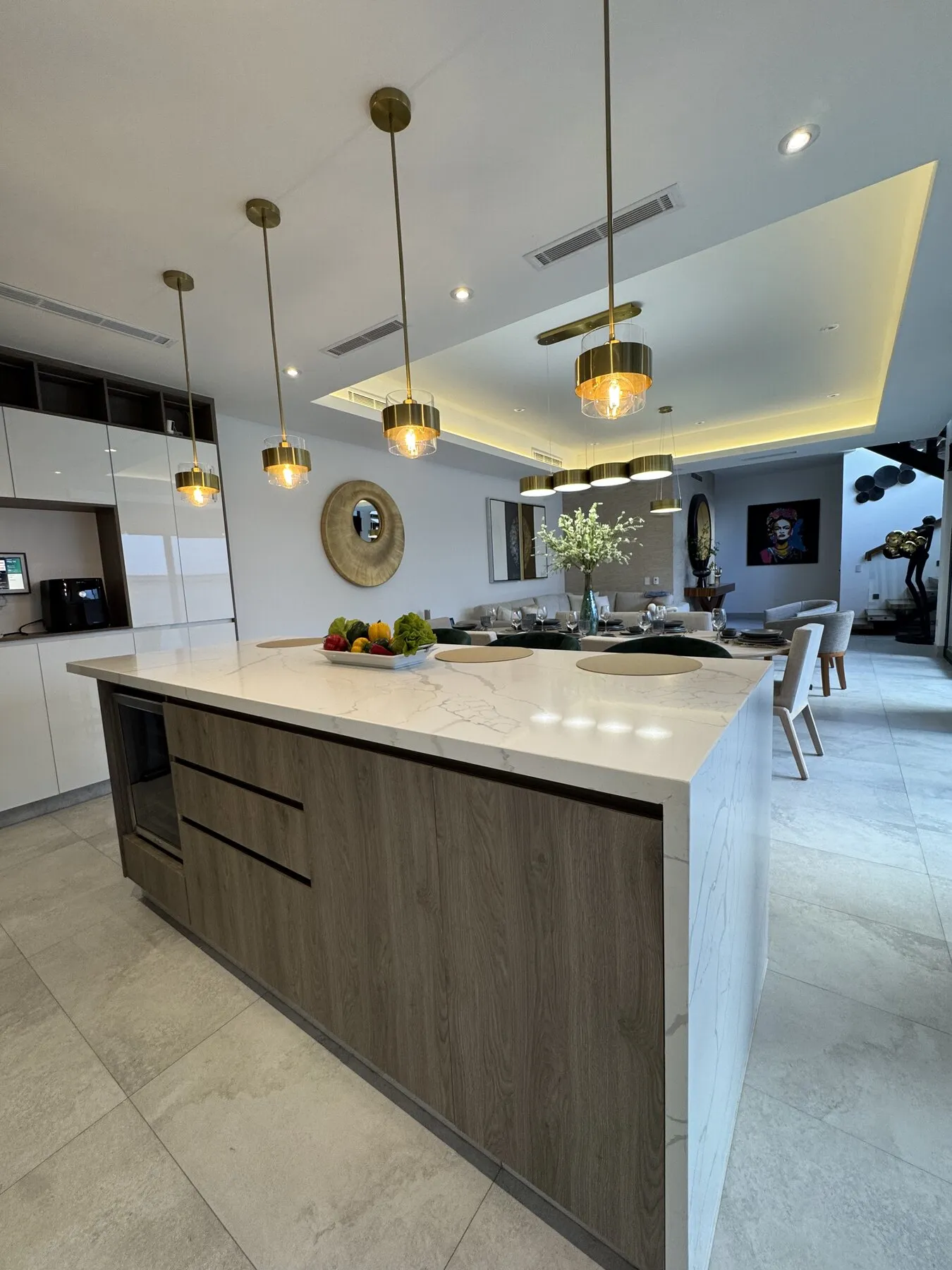 Cocina entregada por Kastell con isla de cubierta blanca, bancos verdes y gabinetes de madera